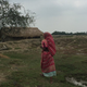 A research participant walking towards her house in West Bengal.